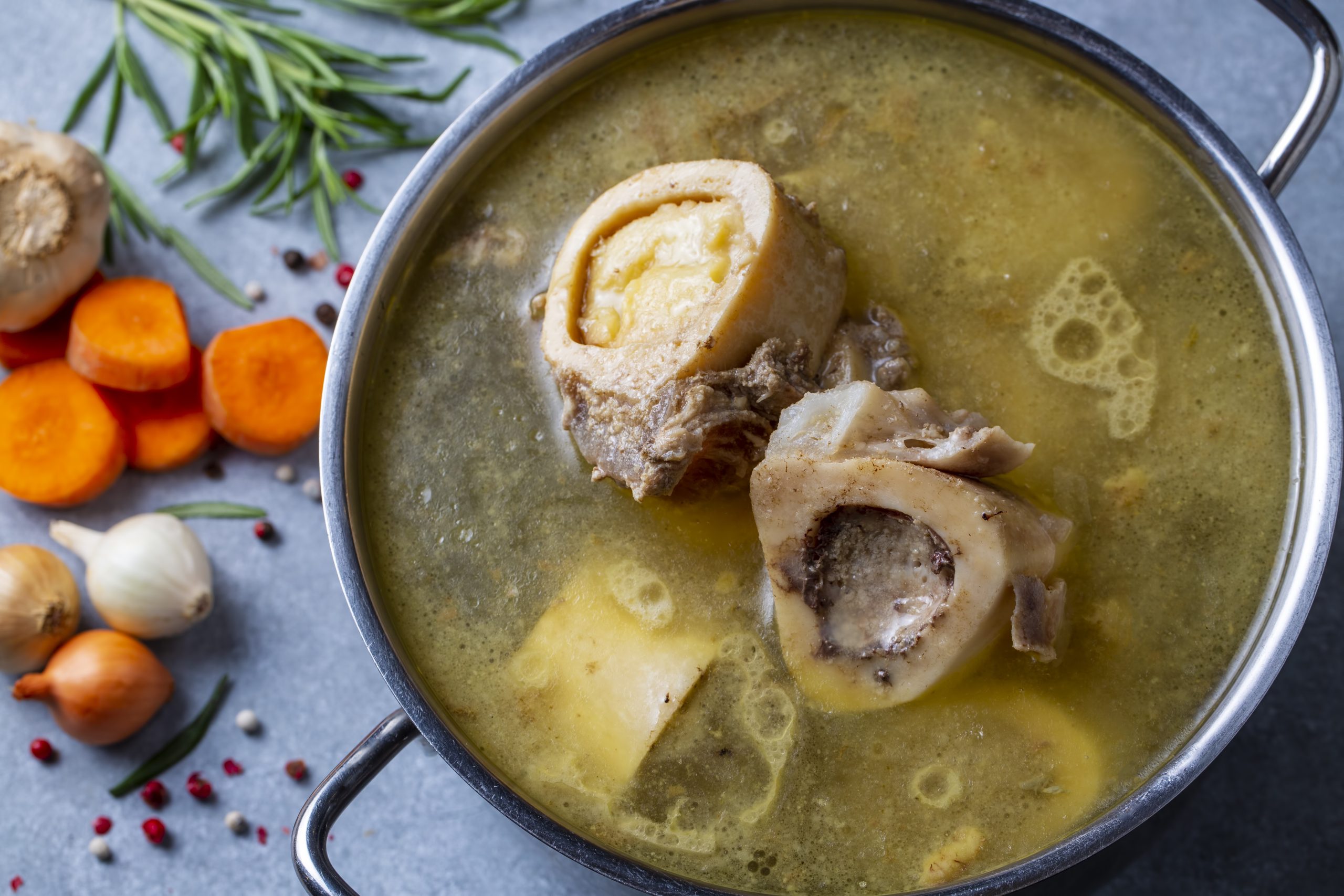 Boiled bone and broth. Homemade beef bone broth is cooked in a p